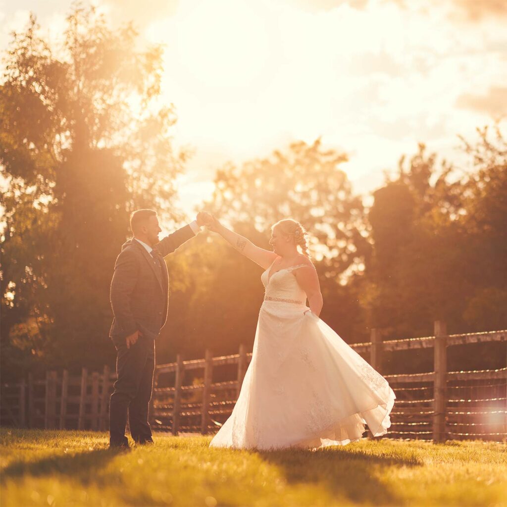 Bride twirls with her wedding dress floating in the wind during golden hour sunshine