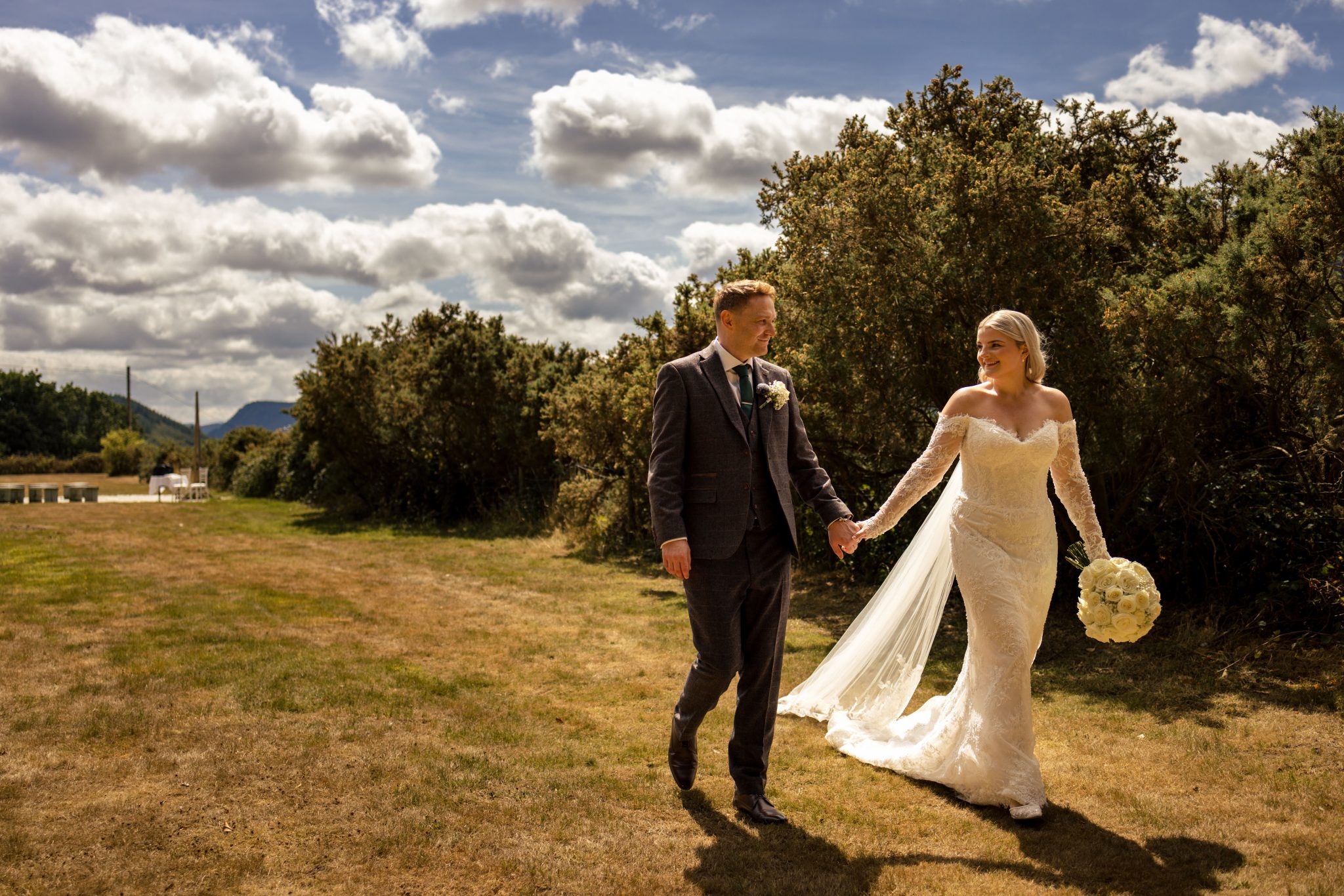 North Wales Wedding Plas Maenan Bride and groom walking hand in hand looking at each other strolling through the grounds of Plas Maenan Country house in North Wales.