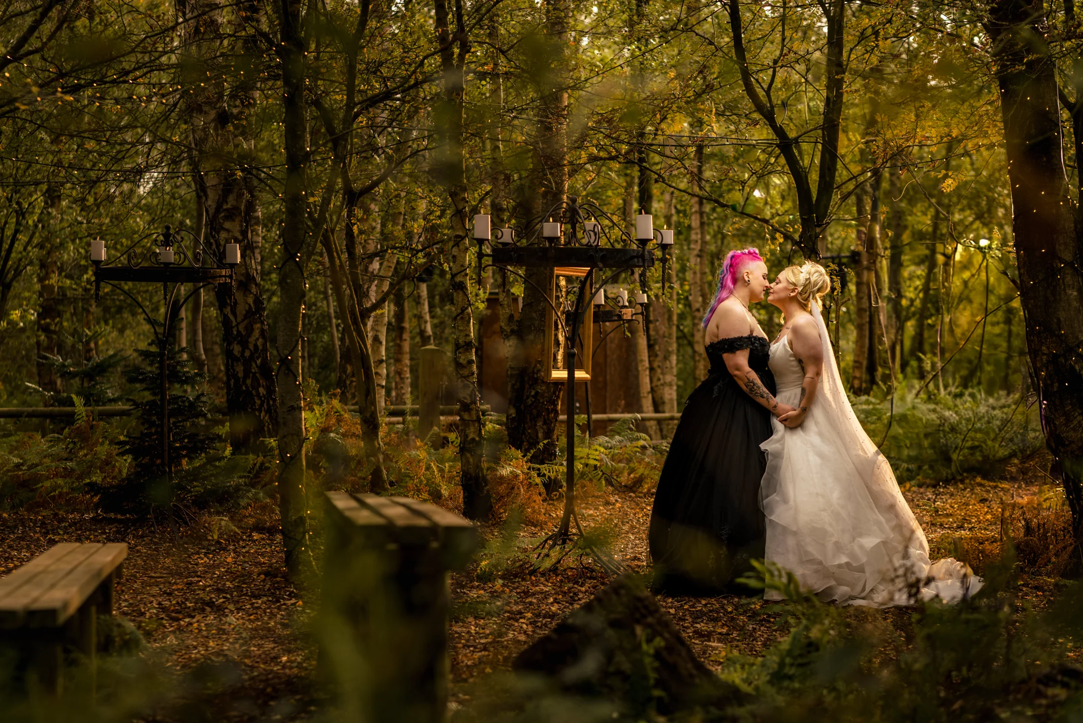 Two brides sharing a kiss at their Cheshire woodland wedding