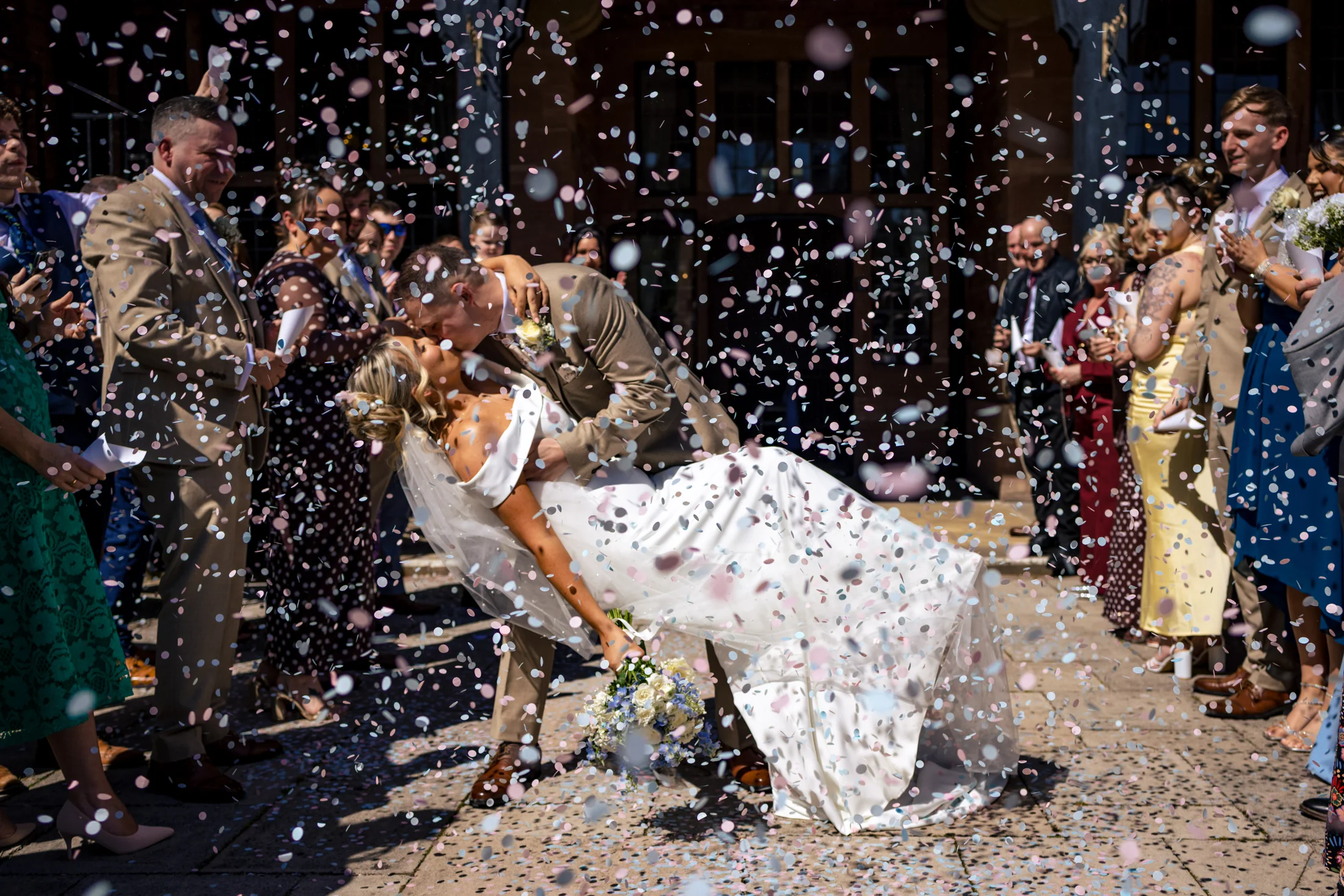 A couple kissing in a shower of confetti at Inglewood Manor
