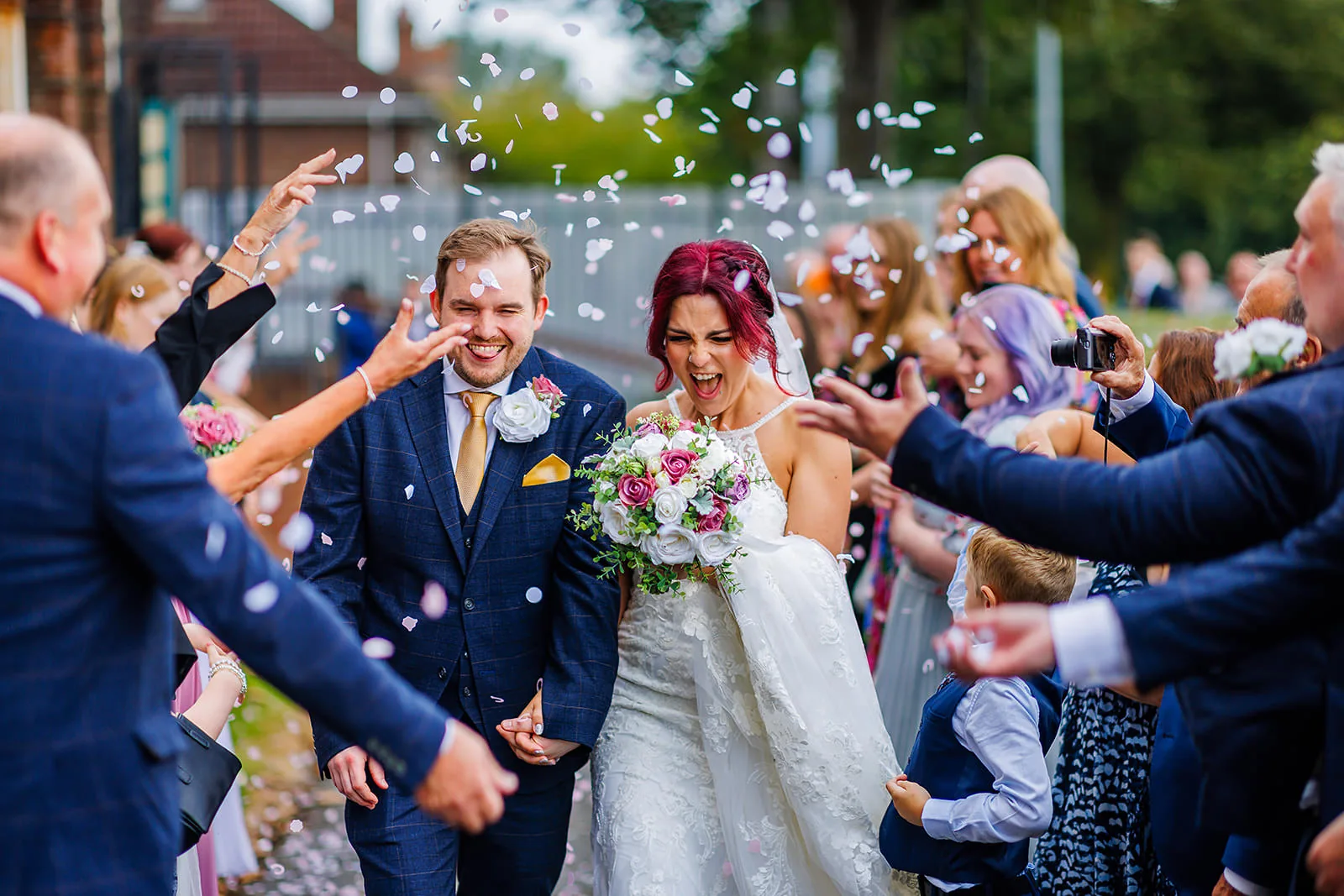 Wedding couple laughing under confetti in Liverpool