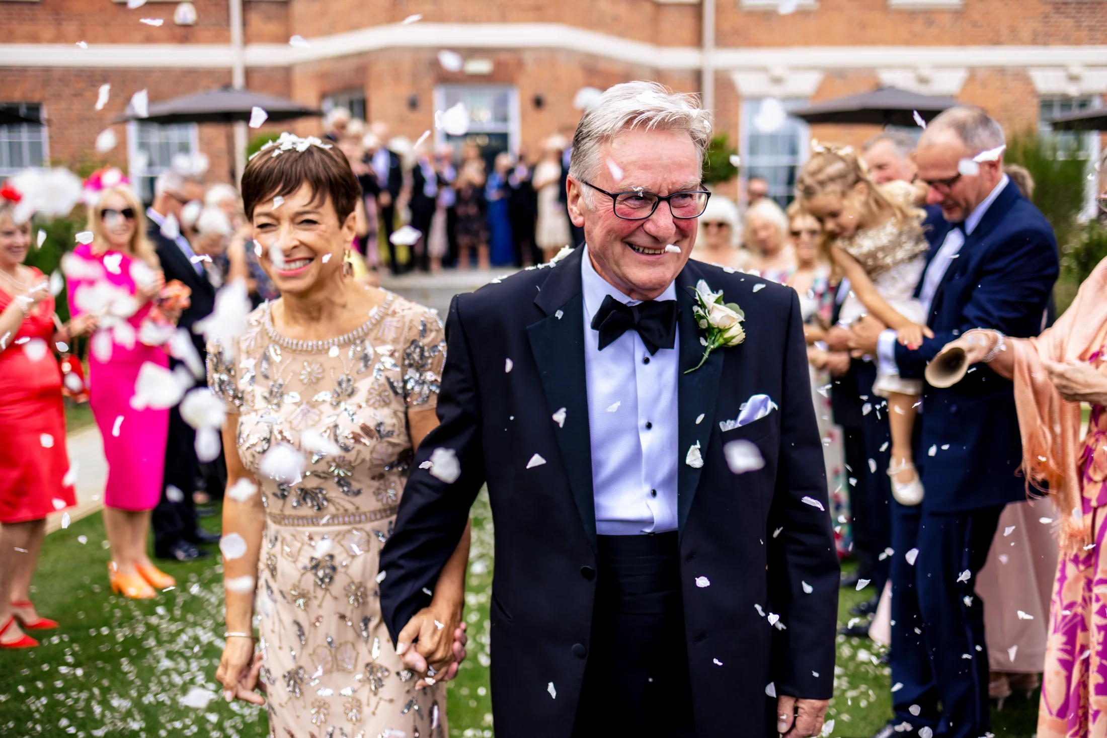 Newlyweds smiling as guests throw confetti at Old Palace Chester