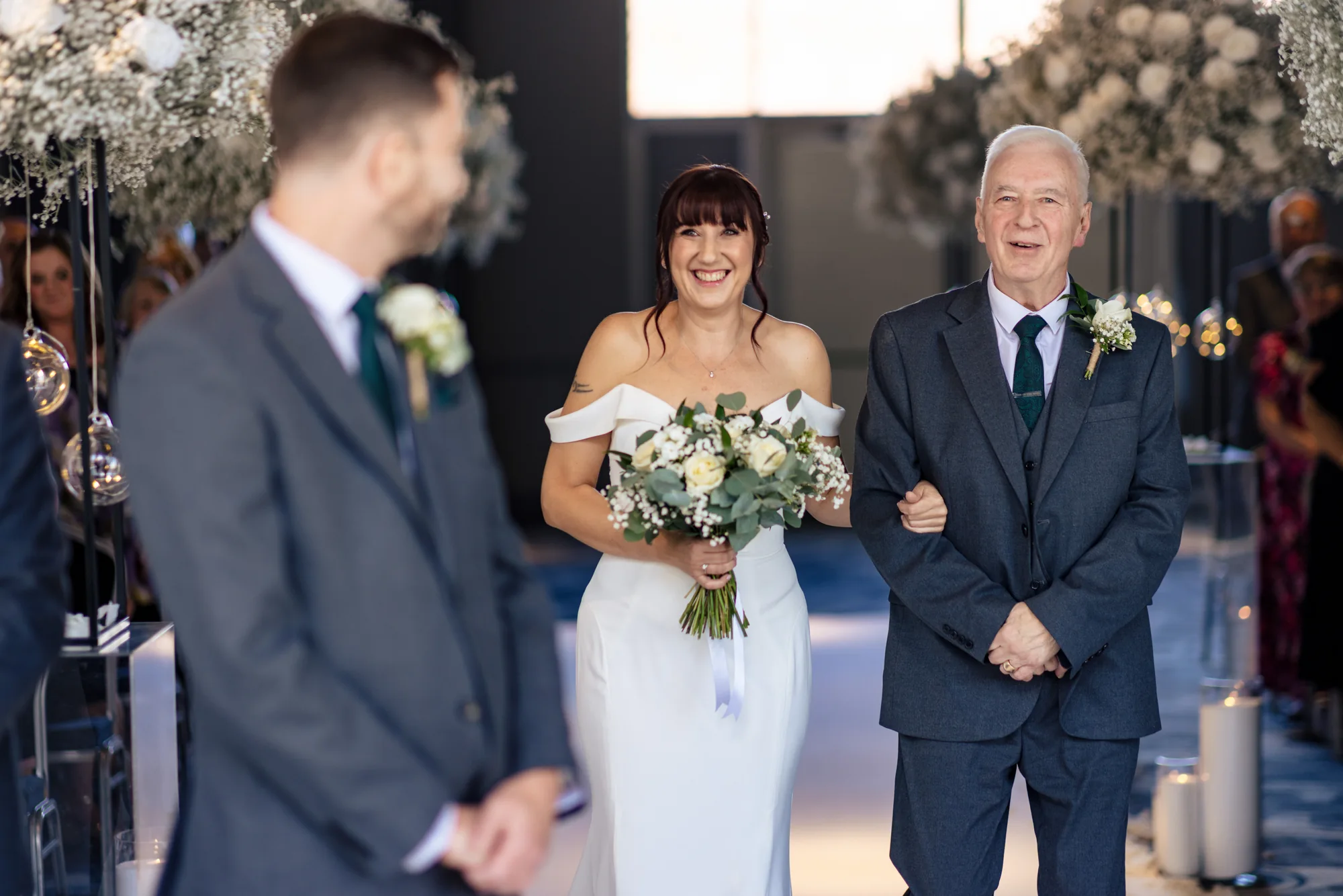 Bride and escort walk towards the groom at Titanic Hotel Liverpool