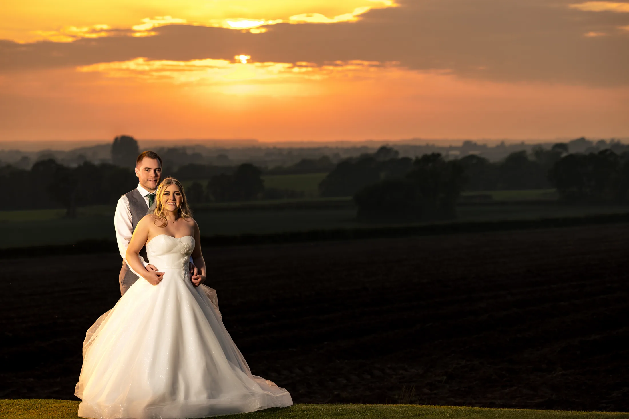 Bride and groom standing together at a North West wedding sunset at West Tower, Lancashire