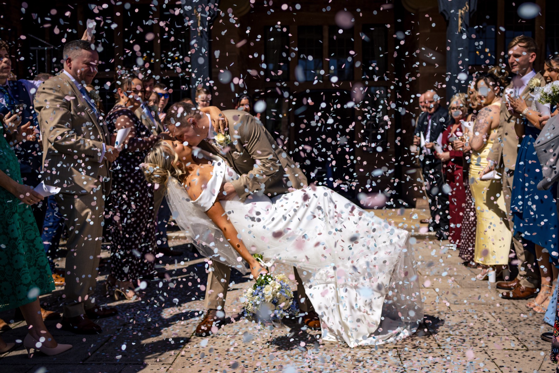 Newlyweds kiss amid confetti and cheering guests at Inglewood Manor