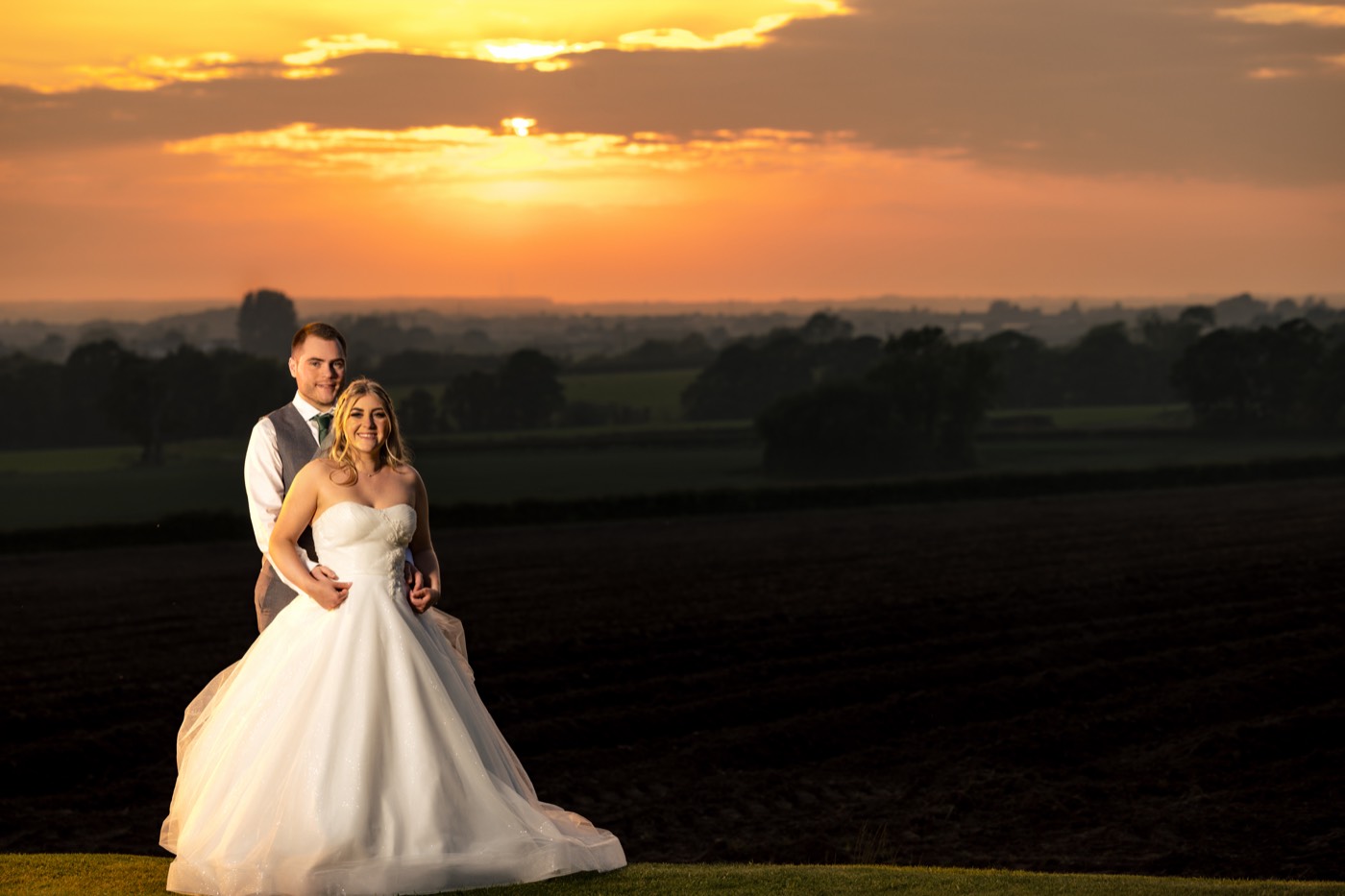 A newlywed couple beneath the golden sunset at West Tower